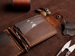 Компактний затиск для купюр пошитий з натуральної шкіри вміщає 7 відділів для карток на кнопці