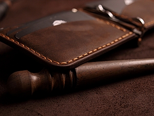 Компактний затиск для купюр пошитий з натуральної шкіри вміщає 7 відділів для карток на кнопці