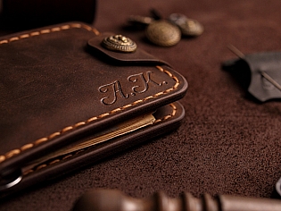 Компактний затиск для купюр пошитий з натуральної шкіри вміщає 7 відділів для карток на кнопці