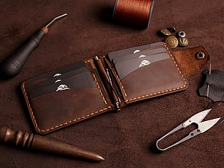 Компактний затиск для купюр пошитий з натуральної шкіри вміщає 7 відділів для карток на кнопці