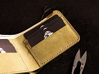 Шкіряний гаманець світло зеленого кольору, пошитий з унікальної італійської шікри Marmoreo. На лицевій тиснення з промальовкою змії, яка зав'язана у кельтський орнамент