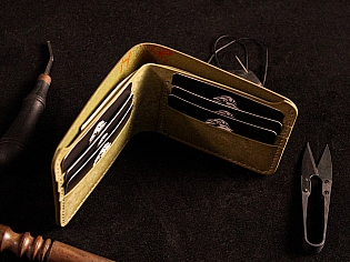 Шкіряний гаманець світло зеленого кольору, пошитий з унікальної італійської шікри Marmoreo. На лицевій тиснення з промальовкою змії, яка зав'язана у кельтський орнамент