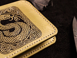 Шкіряний гаманець світло зеленого кольору, пошитий з унікальної італійської шікри Marmoreo. На лицевій тиснення з промальовкою змії, яка зав'язана у кельтський орнамент