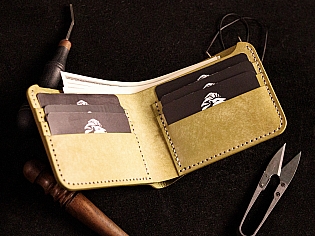 Шкіряний гаманець світло зеленого кольору, пошитий з унікальної італійської шікри Marmoreo. На лицевій тиснення з промальовкою змії, яка зав'язана у кельтський орнамент