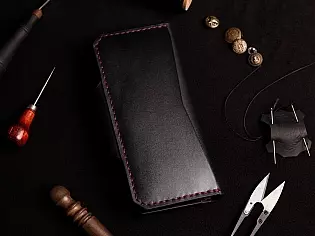 Шкіряне портмоне вміщає два відділи для купюр та дванадцять відділів для карток