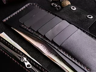 Шкіряне портмоне вміщає два відділи для купюр, 6 відділів для карток та кишеньку для монет на замочку