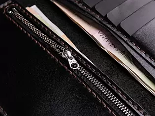 Шкіряне портмоне вміщає два відділи для купюр, 6 відділів для карток та кишеньку для монет на замочку