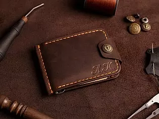 Компактний затиск для купюр пошитий з натуральної шкіри вміщає 7 відділів для карток на кнопці