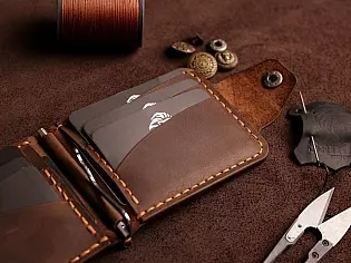 Компактний затиск для купюр пошитий з натуральної шкіри вміщає 7 відділів для карток на кнопці