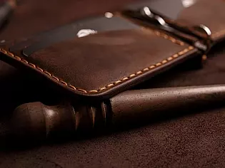 Компактний затиск для купюр пошитий з натуральної шкіри вміщає 7 відділів для карток на кнопці