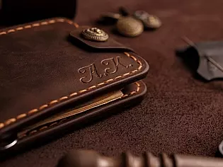 Компактний затиск для купюр пошитий з натуральної шкіри вміщає 7 відділів для карток на кнопці