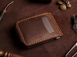 Компактний затиск для купюр пошитий з натуральної шкіри вміщає 7 відділів для карток на кнопці