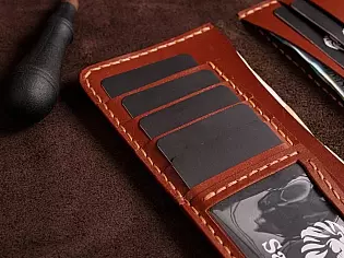 Шкіряний гаманець на рівну купюру вміщає 2 відділи для купюр, 9 карток, 1 відділ для документів та зовнішньою кишеню для монет на замочку