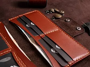 Шкіряний гаманець на рівну купюру вміщає 2 відділи для купюр, 9 карток, 1 відділ для документів та зовнішньою кишеню для монет на замочку