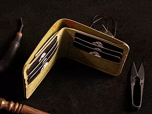 Шкіряний гаманець світло зеленого кольору, пошитий з унікальної італійської шікри Marmoreo. На лицевій тиснення з промальовкою змії, яка зав'язана у кельтський орнамент