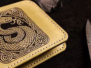 Шкіряний гаманець світло зеленого кольору, пошитий з унікальної італійської шікри Marmoreo. На лицевій тиснення з промальовкою змії, яка зав'язана у кельтський орнамент