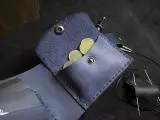 Пошитий вручну шкіряний гаманець вміщає 3 відділи для карток та кишеньку для монет із кнопкою
