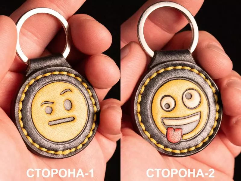 Шкіряний брелок з тисненням смайликів обличчя з підозрілим або вдумливим виразом та усміхнене обличчя з висунутим язиком